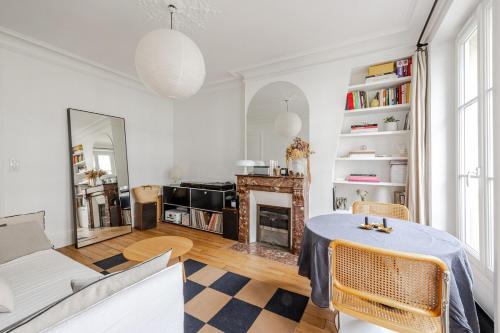 un salon avec une table et une cheminée dans l'établissement Elegant 1-Bedroom Apartment, à Paris