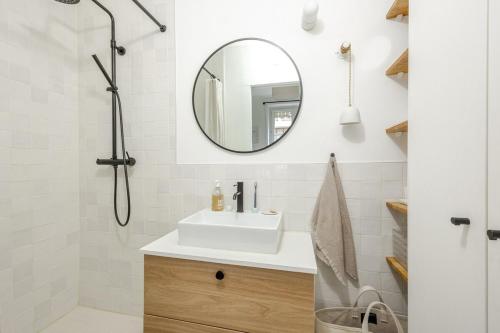 une salle de bain avec un lavabo et un miroir dans l'établissement Elegant 1-Bedroom Apartment, à Paris