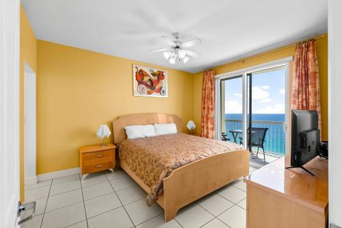 una camera da letto con un letto, una televisione e un balcone di Celadon #2205 a Panama City Beach
