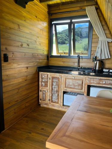 a kitchen with a sink in a wooden cabin at Hotel Guerra - Pousada Montebelo in Jaguaruna