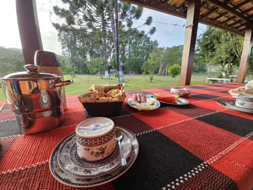 a table with a plate of food and a cup of coffee at Pousada da Elizângela de Amarantina in Ouro Preto