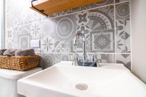 a white sink in a bathroom with a wall at Life Hospitality TJ in Tijuana