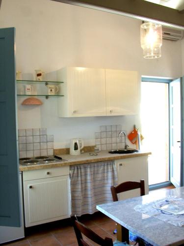a kitchen with white cabinets and a table at Villa Patmos Netia in Patmos