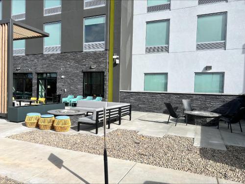 a patio with tables and chairs in front of a building at Home2 Suites By Hilton Bozeman Four Corners in Bozeman