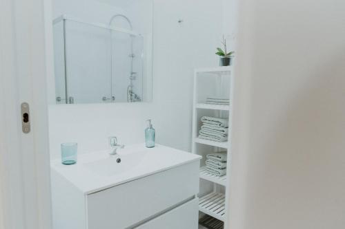 ein weißes Badezimmer mit Waschbecken und Spiegel in der Unterkunft Apartamento Hermi in Torrox