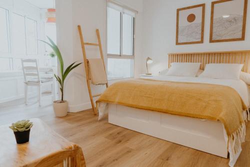 ein Schlafzimmer mit einem großen Bett und einem Tisch in der Unterkunft Apartamento Hermi in Torrox