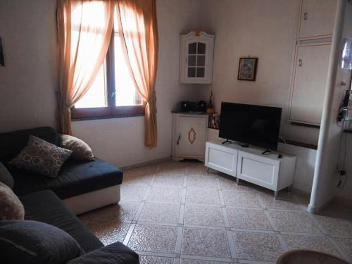a living room with a couch and a flat screen tv at Villa le Arcate in Furore