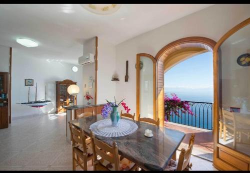 a dining room with a table and a view of the ocean at Villa le Arcate in Furore