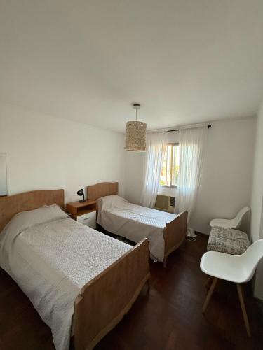 a bedroom with two beds and a chair and a window at Mirador del Puerto in Santa Fe