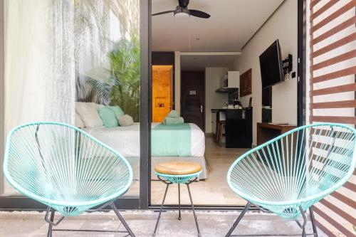 two blue chairs and a bed in a room at Central Playa del Carmen Master Suite with rooftop pool and gym WiFi free parking near beach in Playa del Carmen