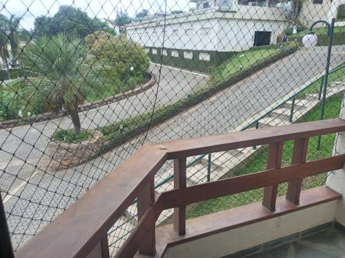 a wooden bench in front of a chain link fence at Flat encantador com lazer in Serra Negra