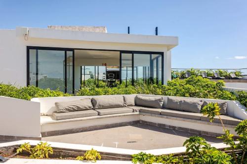 a white couch sitting on top of a house at Central Playa del Carmen Master Suite with rooftop pool and gym WiFi free parking near beach in Playa del Carmen