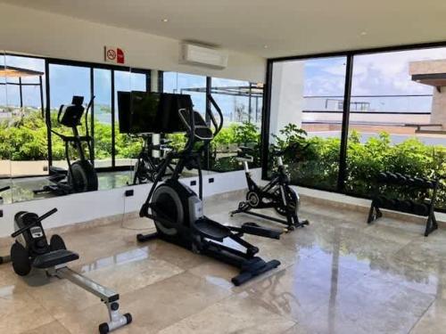 a gym with treadmills and exercise bikes in a building at Central Playa del Carmen Master Suite with rooftop pool and gym WiFi free parking near beach in Playa del Carmen
