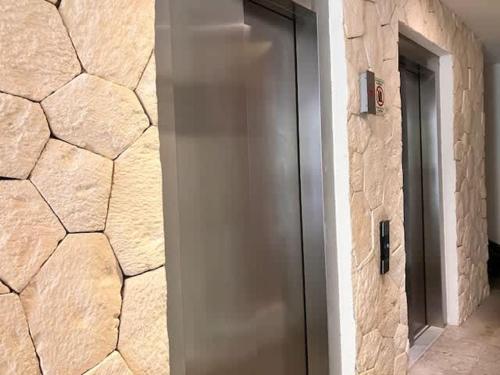 a door in a room with a stone wall at Central Playa del Carmen Master Suite with rooftop pool and gym WiFi free parking near beach in Playa del Carmen