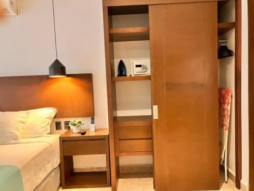 a bedroom with a bed and a book shelf at Central Playa del Carmen Master Suite with rooftop pool and gym WiFi free parking near beach in Playa del Carmen