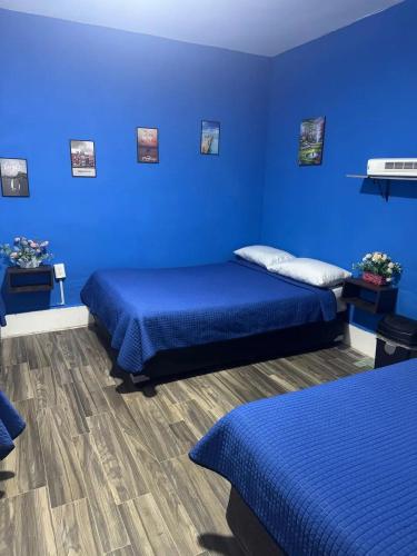 a blue room with two beds with blue walls at Casa Cristal in Mexico City
