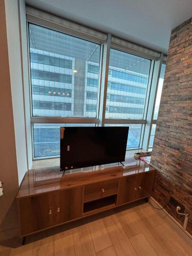 un soggiorno con una TV a schermo piatto davanti a una finestra di Prime studio in centaurus a Islamabad