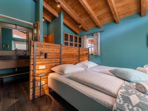 two beds in a room with blue walls at Chalet Schneelöwe XL in Leogang