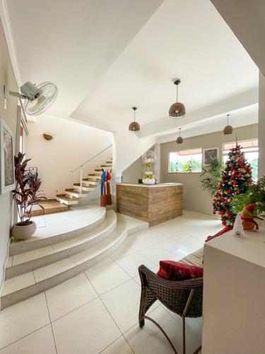 a living room with a christmas tree and stairs at Pousada do Grande Lago in Lindóia