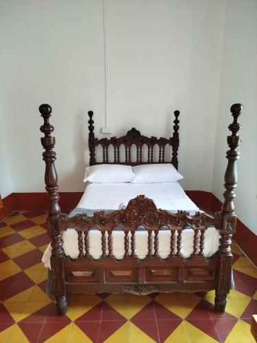 a bed with a wooden frame in a room at La casa de la abuela in Jericó