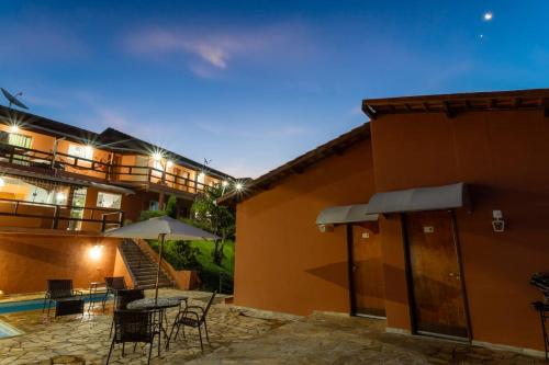 a building with a patio with a table and chairs at Pousada do Grande Lago in Lindóia