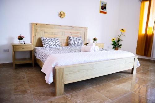 a bedroom with a large bed with a wooden headboard at Vista Mar Malecón Hotel in Cabrera