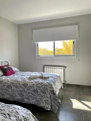 a bedroom with a bed and a window at 3H MALARGUE Duplex calefacción por radiadores in Malargüe