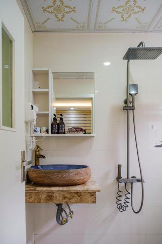 a bathroom with a sink and a mirror at Roza Palace Cat Ba in Cat Ba
