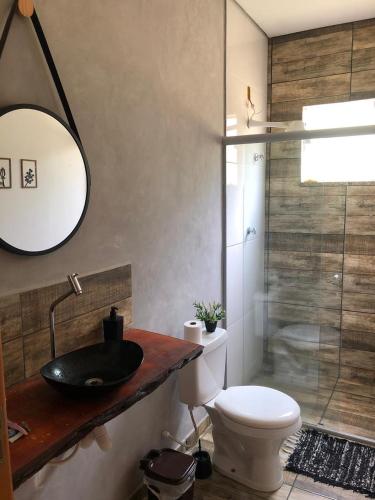 a bathroom with a sink and a toilet and a shower at Chácara Por do Sol in Pouso Alegre