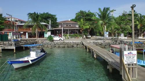 a boat is docked at a dock in the water at Splash Inn Dive Resort & Villas in West End