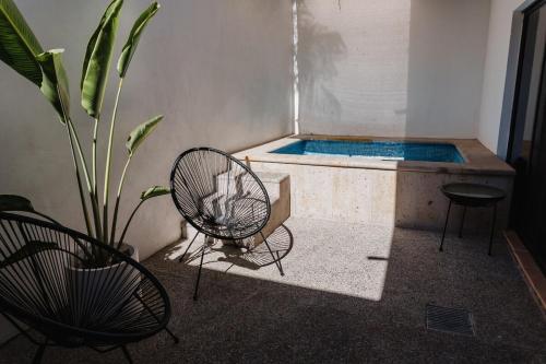 a room with a tub with a chair and a plant at Casa Ola Mita in Punta Mita