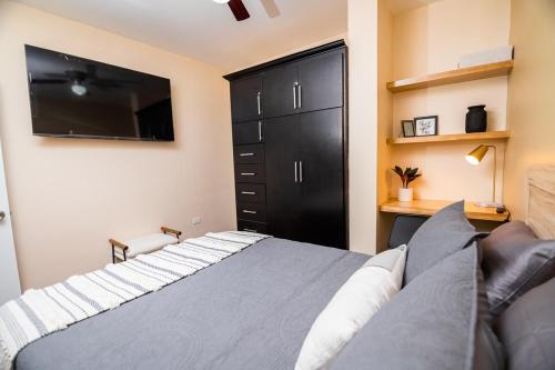 a bedroom with a large bed and a black cabinet at Life Hospitality in Ensenada