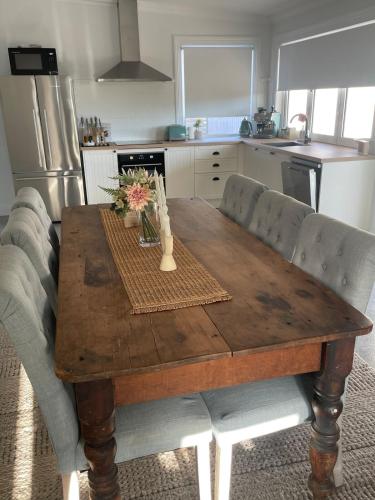 a kitchen with a wooden table with chairs around it at Flume Krondorf Winemakers Haus in Kabininge
