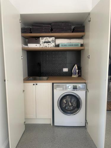 a laundry room with a washing machine in a closet at Flume Krondorf Winemakers Haus in Kabininge