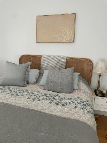 a bed with gray pillows and a picture on the wall at Flume Krondorf Winemakers Haus in Kabininge