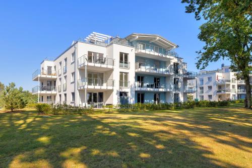 a white apartment building with a large yard at Apartment "Haffbrise" in Zirchow