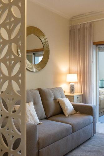 a living room with a couch and a mirror at Estúdio AMar - Always Algarve in Porches