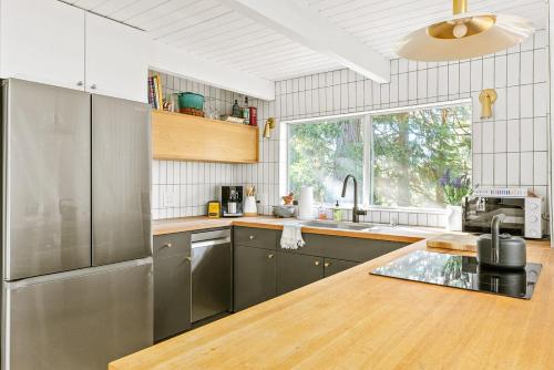 a kitchen with stainless steel appliances and a wooden counter at Luxury A-Frame Retreat in Lake Arrowhead