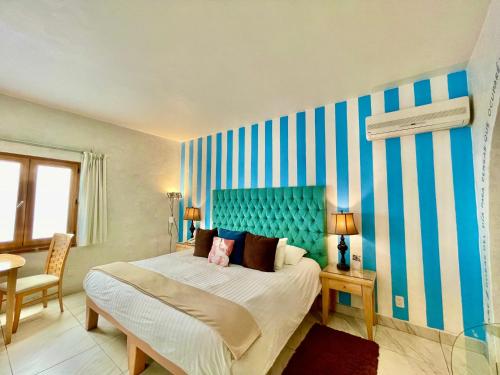プエブラにあるEl Sueño Hotel & Spaのベッドルーム1室(大型ベッド1台、青いヘッドボード付)