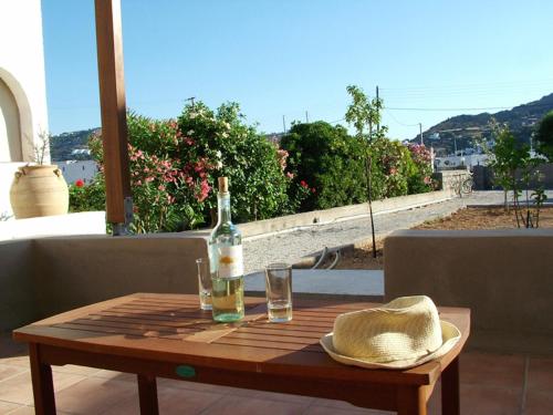a bottle of wine and a hat on a wooden table at Villa Patmos Netia in Patmos