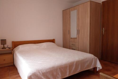 a bedroom with a bed and a wooden cabinet at Apartments by the sea Cove Pjestata, Peljesac - 24021 in Janjina