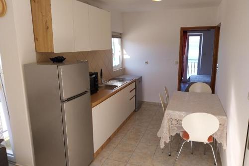 a small kitchen with a table and a refrigerator at Apartments by the sea Cove Pjestata, Peljesac - 24021 in Janjina