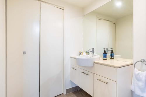 a white bathroom with a sink and a mirror at Port Douglas Sea Breeze Villa 2 in Port Douglas