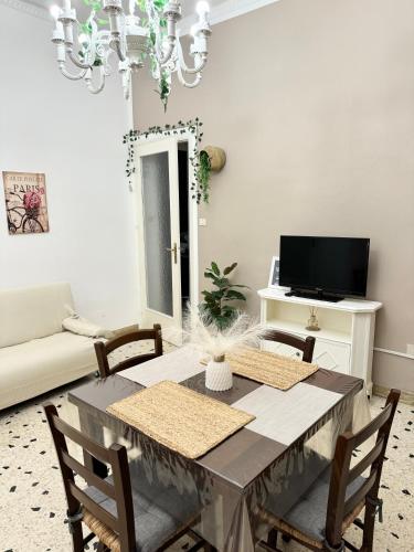 a dining room with a table with chairs and a television at Da Turiddu in Cinisi