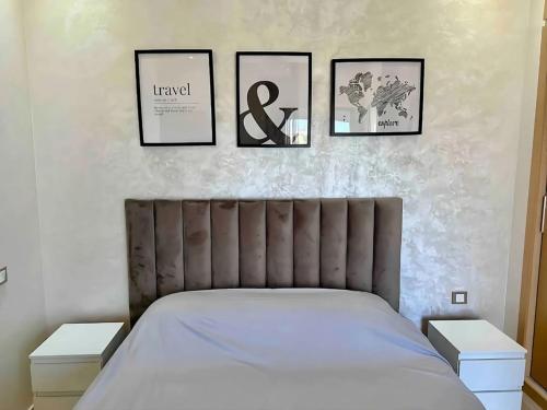 a bedroom with three pictures on the wall and a bed at Cosy Apartment with sea view in Sidi Rahal