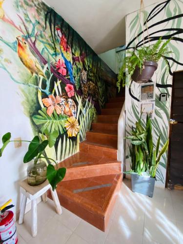 a mural of a staircase with plants on the wall at Casa Semilla in Holbox Island
