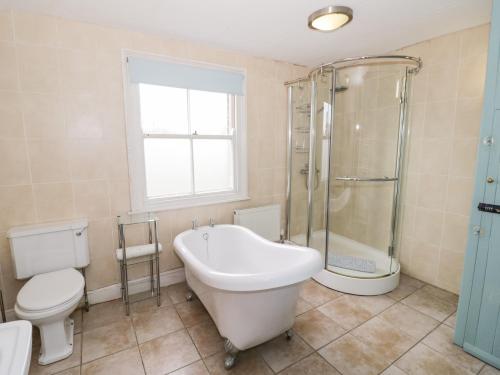 a bathroom with a tub and a toilet and a shower at The Lock House in Gloucester