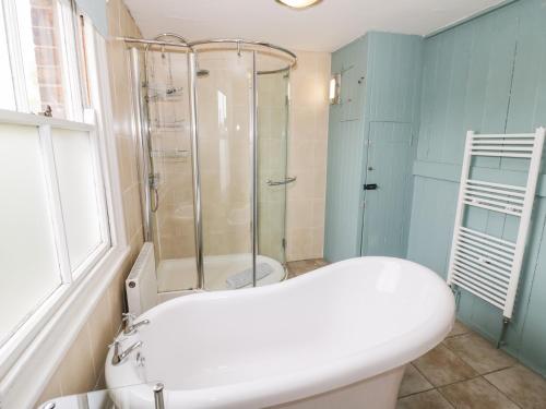 a bathroom with a shower and a white bath tub at The Lock House in Gloucester