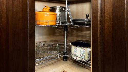 a cupboard with a kitchen utensils and dishes in a refrigerator at Lakefront Retreat - Boat - Fish - Close to all Orlando Parks - Disney - Universal - SeaWorld in Orlando