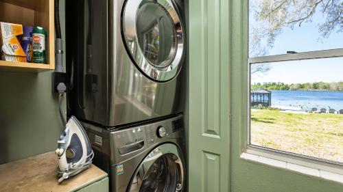 a washer and dryer in a room with a window at Lakefront Retreat - Boat - Fish - Close to all Orlando Parks - Disney - Universal - SeaWorld in Orlando